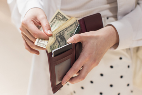person counting money in wallet
