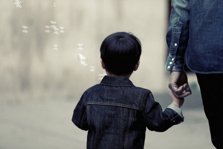 Child holding an adults hand to symbolize supervised visitation in Massachusetts